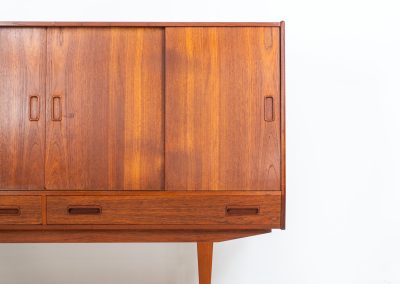Teak highboard by P. Westergaard (Denmark, 1960s). This beautiful highboard comes with four sliding Doors and two wide drawers. It has beautiful teak wood patterns, nice inset handels and tons of storage space on the inside. Its in very good vintage condition with a few repair marks and small age related using traces. Labeled by maker.