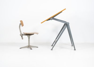 “Reply” drafting table and chair by Wim Rietveld & Friso Kramer for Ahrend de Cirkel (The Netherlands, 1950s). This highly adjustable collaboration by Friso Kramer & Wim Rietveld makes it possible to use the table at any preferred height and position. It won the prestigious ‘Singe d’Or’ in Brussels 1963. It consists of an enameled metal frame and a wooden top which both have a nice patina and age related using traces. A perfect piece to use as a writing desk or architect table. The table and chair are both marked by maker.