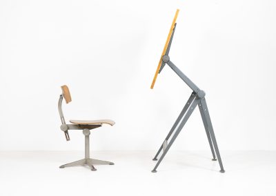 “Reply” drafting table and chair by Wim Rietveld & Friso Kramer for Ahrend de Cirkel (The Netherlands, 1950s). This highly adjustable collaboration by Friso Kramer & Wim Rietveld makes it possible to use the table at any preferred height and position. It won the prestigious ‘Singe d’Or’ in Brussels 1963. It consists of an enameled metal frame and a wooden top which both have a nice patina and age related using traces. A perfect piece to use as a writing desk or architect table. The table and chair are both marked by maker.
