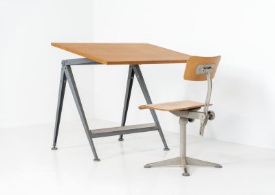 “Reply” drafting table and chair by Wim Rietveld & Friso Kramer for Ahrend de Cirkel (The Netherlands, 1950s). This highly adjustable collaboration by Friso Kramer & Wim Rietveld makes it possible to use the table at any preferred height and position. It won the prestigious ‘Singe d’Or’ in Brussels 1963. It consists of an enameled metal frame and a wooden top which both have a nice patina and age related using traces. A perfect piece to use as a writing desk or architect table. The table and chair are both marked by maker.