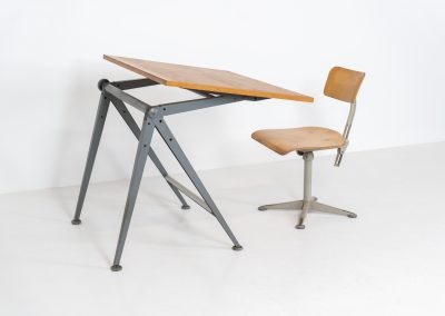 “Reply” drafting table and chair by Wim Rietveld & Friso Kramer for Ahrend de Cirkel (The Netherlands, 1950s). This highly adjustable collaboration by Friso Kramer & Wim Rietveld makes it possible to use the table at any preferred height and position. It won the prestigious ‘Singe d’Or’ in Brussels 1963. It consists of an enameled metal frame and a wooden top which both have a nice patina and age related using traces. A perfect piece to use as a writing desk or architect table. The table and chair are both marked by maker.