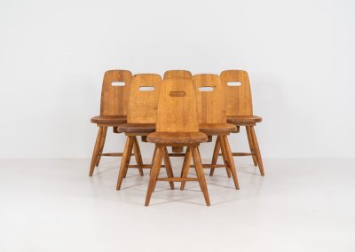 Set of six rare “Pirtti” dining chairs by Eero Aarnio for Laukaan Puu (Finland, 1960s). This exceptional set of “Pirtti” dining chairs by Eero Aarnio stands out from the more common pine versions, as they are crafted from solid oak. Their bold, sculptural design strikes a balance between brutalism and organic softness, with rounded edges and a strong, grounded presence. The oak has aged beautifully over time, with each chair showcasing a unique patina and subtle variations in wood grain and tone. While they bear visible signs of use, these natural imperfections only enhance their character, giving them a rich, lived-in warmth.