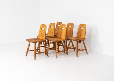 Set of six rare “Pirtti” dining chairs by Eero Aarnio for Laukaan Puu (Finland, 1960s). This exceptional set of “Pirtti” dining chairs by Eero Aarnio stands out from the more common pine versions, as they are crafted from solid oak. Their bold, sculptural design strikes a balance between brutalism and organic softness, with rounded edges and a strong, grounded presence. The oak has aged beautifully over time, with each chair showcasing a unique patina and subtle variations in wood grain and tone. While they bear visible signs of use, these natural imperfections only enhance their character, giving them a rich, lived-in warmth.
