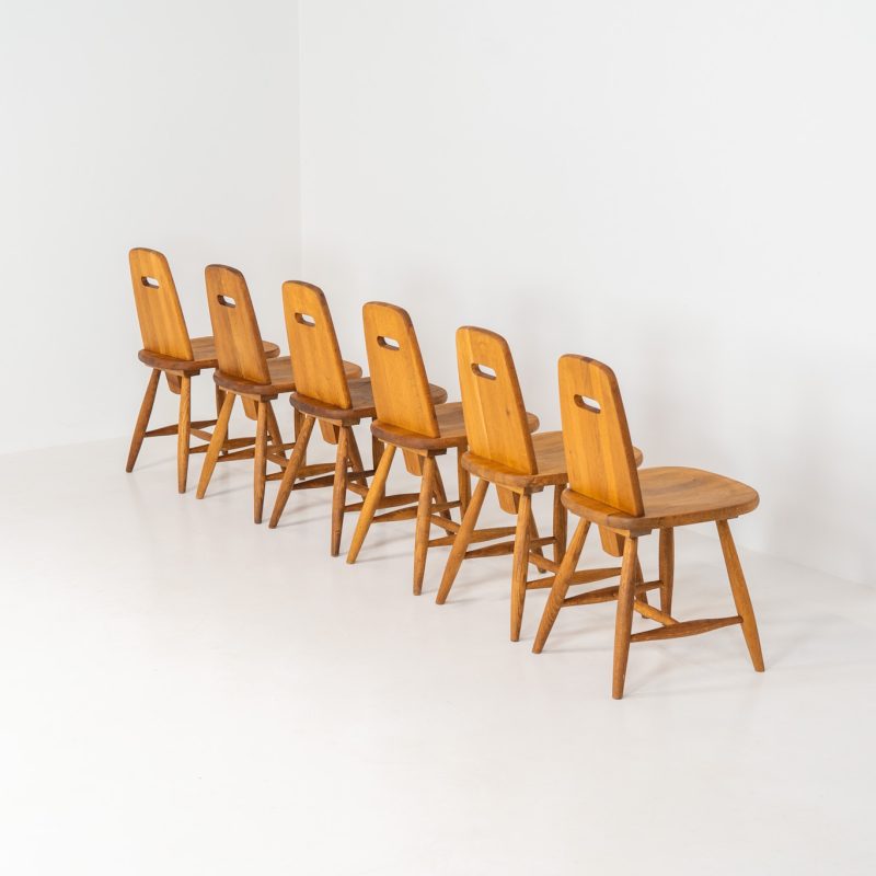 Set of six rare “Pirtti” dining chairs by Eero Aarnio for Laukaan Puu (Finland, 1960s). This exceptional set of “Pirtti” dining chairs by Eero Aarnio stands out from the more common pine versions, as they are crafted from solid oak. Their bold, sculptural design strikes a balance between brutalism and organic softness, with rounded edges and a strong, grounded presence. The oak has aged beautifully over time, with each chair showcasing a unique patina and subtle variations in wood grain and tone. While they bear visible signs of use, these natural imperfections only enhance their character, giving them a rich, lived-in warmth.