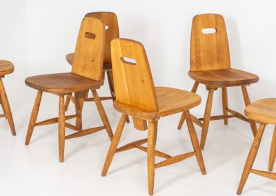 Set of six rare “Pirtti” dining chairs by Eero Aarnio for Laukaan Puu (Finland, 1960s). This exceptional set of “Pirtti” dining chairs by Eero Aarnio stands out from the more common pine versions, as they are crafted from solid oak. Their bold, sculptural design strikes a balance between brutalism and organic softness, with rounded edges and a strong, grounded presence. The oak has aged beautifully over time, with each chair showcasing a unique patina and subtle variations in wood grain and tone. While they bear visible signs of use, these natural imperfections only enhance their character, giving them a rich, lived-in warmth.