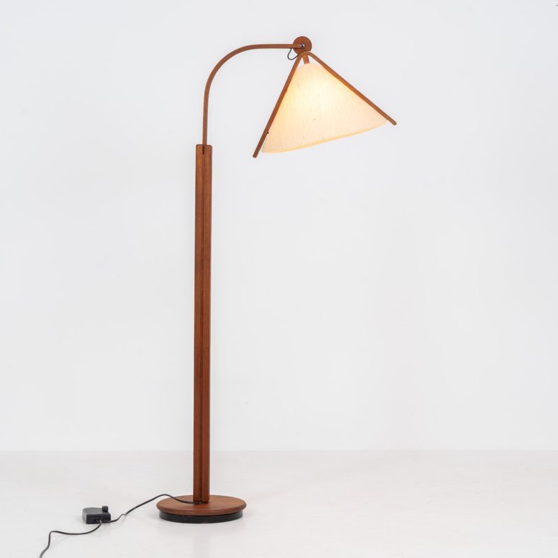 Sculptural teak floor lamp by Domus (Germany, 1970s). This elegant beauty features a sculptural solid teak stem and base, paired with a wild-silk lampshade. The lamp is easily adjustable in height and angle and is controlled with a dimmer switch. The floor lamp remains in its original, very good condition!
