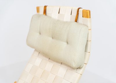 “Miranda” easy chair by Bruno Mathsson Design Studio (Sweden, 1970s). Originally designed by Bruno Mathsson in 1941, this exceptional “Miranda” easy chair was manufactured in the 1970s. It features a beautifully curved, molded beech plywood frame with a linen webbing seat and an adjustable headrest, suspended by leather straps. The chair is in good vintage condition, showing signs of use such as marks, fabric fraying, and some damage to the wood, all of which add to its authentic character. Marked by maker.