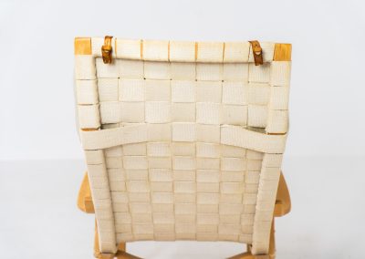 “Miranda” easy chair by Bruno Mathsson Design Studio (Sweden, 1970s). Originally designed by Bruno Mathsson in 1941, this exceptional “Miranda” easy chair was manufactured in the 1970s. It features a beautifully curved, molded beech plywood frame with a linen webbing seat and an adjustable headrest, suspended by leather straps. The chair is in good vintage condition, showing signs of use such as marks, fabric fraying, and some damage to the wood, all of which add to its authentic character. Marked by maker.