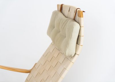 “Miranda” easy chair by Bruno Mathsson Design Studio (Sweden, 1970s). Originally designed by Bruno Mathsson in 1941, this exceptional “Miranda” easy chair was manufactured in the 1970s. It features a beautifully curved, molded beech plywood frame with a linen webbing seat and an adjustable headrest, suspended by leather straps. The chair is in good vintage condition, showing signs of use such as marks, fabric fraying, and some damage to the wood, all of which add to its authentic character. Marked by maker.