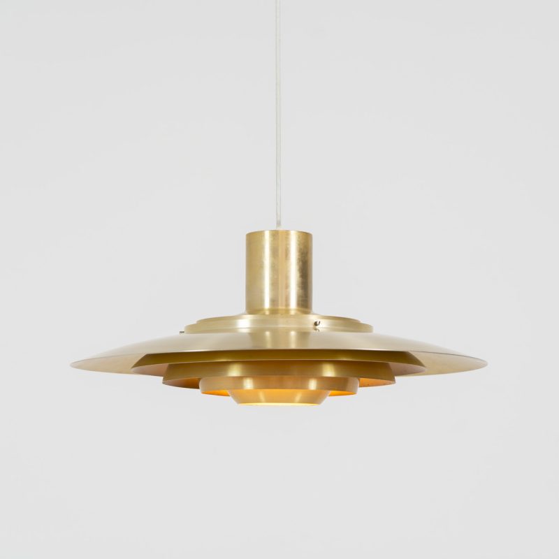 Early “P376” brass pendant light by Jørgen Kastholm & Preben Fabricius for Nordisk Solar (Denmark, 1960s). This magnificent lamp features a series of gently curved, layered brass anodized aluminum shades that create a stunning glow. Designed in the 1960s, it exemplifies Danish modernism with its clean lines and refined aesthetic, making it a timeless choice for both classic and contemporary interiors. The P376 is a true design icon! The lamp is in good vintage condition with a beautiful patina. It has some surface scratches and age related discolorations.