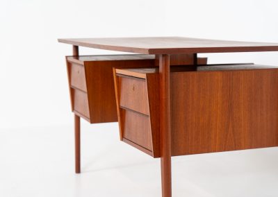 Freestanding desk by Gunnar Nielsen Tibergaard (Denmark, 1960s). A beautifully designed and elegant teak desk from the 1960s, featuring four drawers and a finished back that allows it to stand freely in any space. The rear side includes an open storage area/bookcase and a cabinet with a drop-down leaf. The desk is in very good condition with one very small chip in the wood on the right back-corner as shown on the pictures.