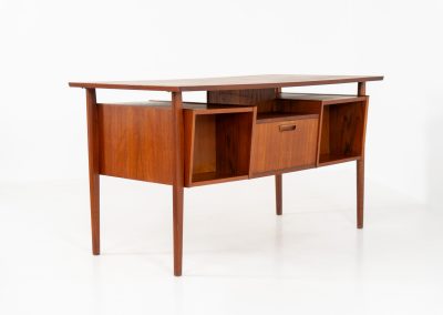 Freestanding desk by Gunnar Nielsen Tibergaard (Denmark, 1960s). A beautifully designed and elegant teak desk from the 1960s, featuring four drawers and a finished back that allows it to stand freely in any space. The rear side includes an open storage area/bookcase and a cabinet with a drop-down leaf. The desk is in very good condition with one very small chip in the wood on the right back-corner as shown on the pictures.