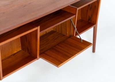 Freestanding desk by Gunnar Nielsen Tibergaard (Denmark, 1960s). A beautifully designed and elegant teak desk from the 1960s, featuring four drawers and a finished back that allows it to stand freely in any space. The rear side includes an open storage area/bookcase and a cabinet with a drop-down leaf. The desk is in very good condition with one very small chip in the wood on the right back-corner as shown on the pictures.