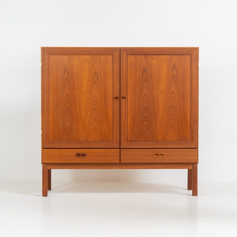Teak highboard in the manner of H.W. Klein (Denmark, 1960s). The highboard is made out of teak and features loads of storage space with two drawers and two spacious doors with adjustable shelves on the inside. It has wonderful drawings in the wood and nice inset handles. It’s in very good condition!
