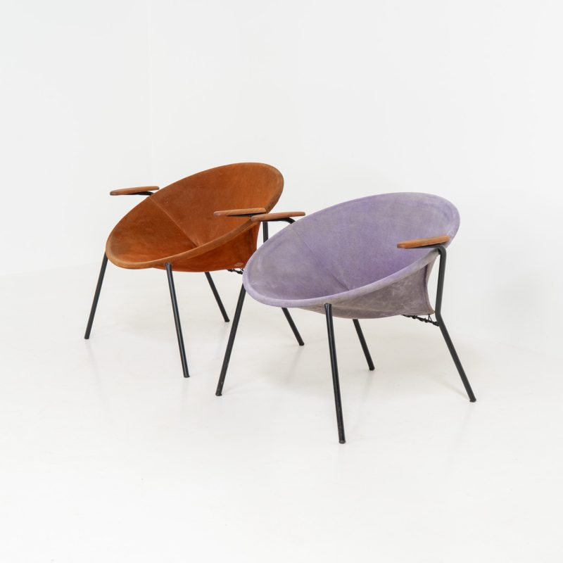 Pair of “Balloon” chairs by Hans Olsen for Lea Design (Denmark, 1950s). This rare and iconic pair of armchairs features a sleek black metal frame, solid teak armrests, and suede leather seats, one in orange and the other in lilac. The aged suede has developed a beautiful patina, adding character to these lightweight and versatile pieces. Both chairs are in good condition with visible signs of use. The orange chair has two repair patches on the back.