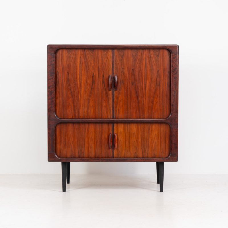 Stunning media cabinet in rosewood by Svend Dyrlund (Denmark, 1960s). What a piece! Designed by Dyrlund and crafted out of Brazilian rosewood, this piece resembles wonderful Danish craftsmanship and eye to detail with its smooth tambour doors, organic shapes ans retractable shelve. It’s super functional and convenient. The slightly deeper design and factory cut holes make this a perfect piece to hide away a small television or audio equipment. In very good condition with some age related using traces.