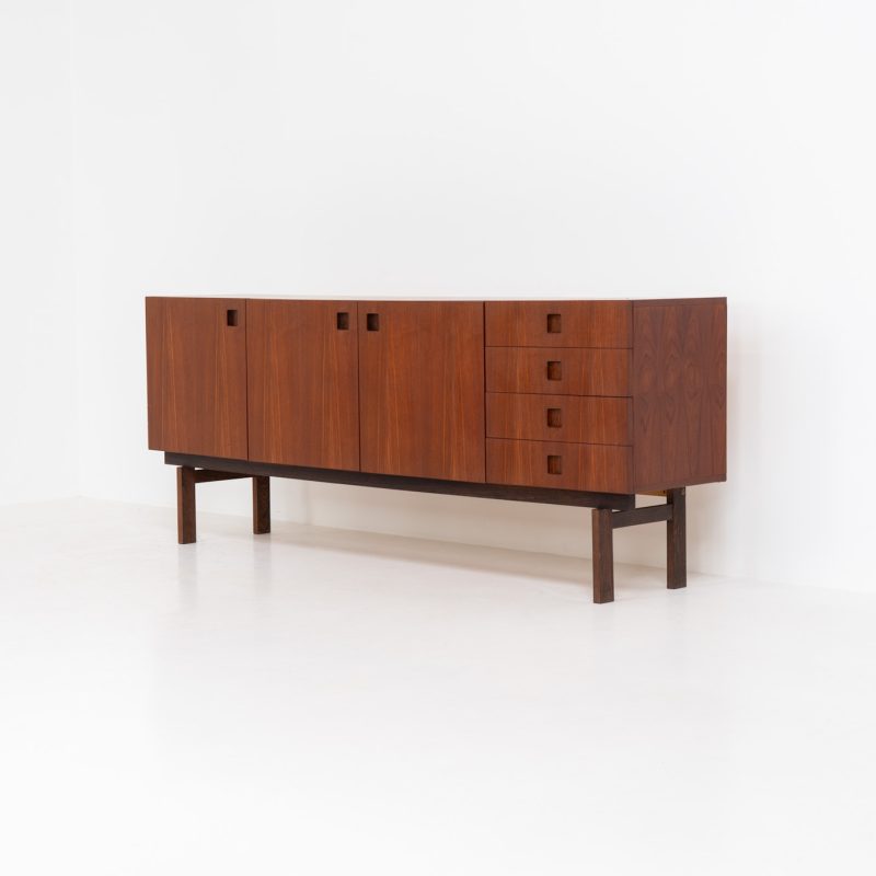 Rare “Propos series” sideboard in Teak & Wengé by Hulmefa (The Netherlands, 1950s). A striking and hard-to-find piece from the 1950s, this “Propos” sideboard by Hulmefa showcases pure elegance. Crafted from warm teak and set on a refined wengé base, it features three doors and four drawers, each adorned with sculptural inset handles in solid wengé, adding a beautiful tactile and visual detail. The sideboard is in very good condition and offers both style and functionality, making it a standout addition to any interior.