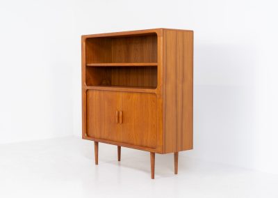 Beautiful bookcase in teak by Svend Dyrlund with tambour doors (Denmark, 1960s). This bookcase perfectly combines organic shapes and loads of detail, like the tambour sliding doors, the beautiful handles or the bulky shelves, which are adjustable in height. It offers lots of storage space! In mint condition!