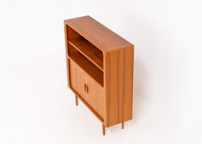 Beautiful bookcase in teak by Svend Dyrlund with tambour doors (Denmark, 1960s). This bookcase perfectly combines organic shapes and loads of detail, like the tambour sliding doors, the beautiful handles or the bulky shelves, which are adjustable in height. It offers lots of storage space! In mint condition!