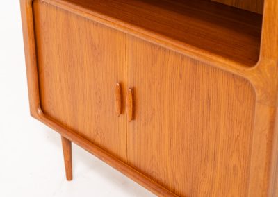 Beautiful bookcase in teak by Svend Dyrlund with tambour doors (Denmark, 1960s). This bookcase perfectly combines organic shapes and loads of detail, like the tambour sliding doors, the beautiful handles or the bulky shelves, which are adjustable in height. It offers lots of storage space! In mint condition!