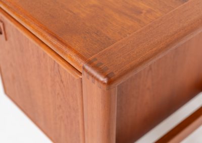 Rare executive writing desk by H.P. Hansen (Denmark, 1950s). This large and exceptionally beautiful piece is a true example of top-quality Danish craftsmanship. Made from solid teak, it showcases elegant aesthetics with softly rounded edges and sculptural inset handles. The spacious desktop highlights a striking wood grain and is complemented by three drawers, a cabinet, and two open shelves at the back. The desk is finished on both sides, making it an ideal statement piece for placement in the center of a room. It is in excellent condition, with only minor discoloration on the top and light signs of use on the drawers.