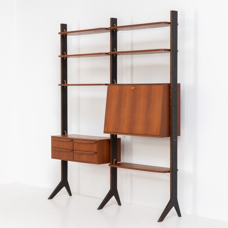 Gorgeous modular wall unit / room devider in teak (Sweden, 1950s). A striking piece that combines elegance and functionality. It features a chest of drawers with sculptural handles, a bar cabinet, and six beautifully rounded shelves, all supported by three black wooden Y-shaped legs. The system is fully modular, allowing you to arrange the elements to your preference. The back is neatly finished, making it ideal for use as a room divider. In very good condition, with only minor surface scratches on the legs.