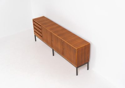 XL Modernist sideboard by Behr Möbel (Germany, 1950s). This striking modernist sideboard was produced in the 1950s by the renowned German manufacturer Behr Möbel, best known for the iconic B40 model. Expertly crafted from rich teak wood, the piece rests on a sleek metal base that adds to its architectural presence. It features four drawers and three doors, offering generous storage space with adjustable shelves inside. The sideboard is in very good condition, with fully functional locks.
