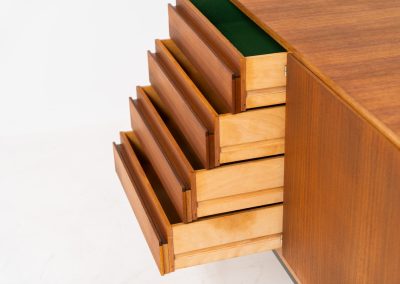 XL Modernist sideboard by Behr Möbel (Germany, 1950s). This striking modernist sideboard was produced in the 1950s by the renowned German manufacturer Behr Möbel, best known for the iconic B40 model. Expertly crafted from rich teak wood, the piece rests on a sleek metal base that adds to its architectural presence. It features four drawers and three doors, offering generous storage space with adjustable shelves inside. The sideboard is in very good condition, with fully functional locks.