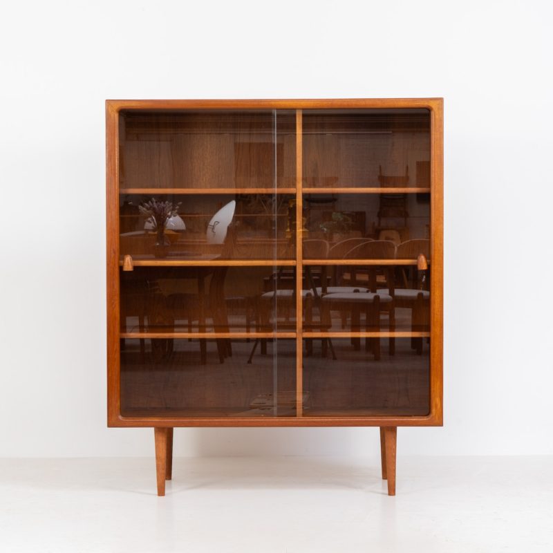 Refined showcase by Svend Dyrlund (Denmark, 1960s). This exceptional piece features elegant glass doors with beautifully crafted wooden handles, six adjustable shelves and a stunning organic appearance. Made from rich teak with a natural woodgrain, it perfectly combines functionality with the timeless characteristic of Danish modern design. In splendid condition.