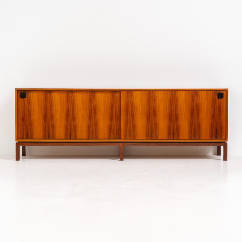 Exceptional XL rosewood sideboard by Alfred Hendrickx for Belform (Belgium, 1960s). This minimalist masterpiece is one of our all time favorites, designed by the renowned modernist Alfred Hendrickx. It is crafted out of rosewood and has an absolutely mesmerizing woodgrain. The sideboard features two large sliding doors, lots of storage space and four drawers on the inside. This example, with the solid rosewood base and black handles, is a rarity to find and is in unbelievably good condition! Marked by maker.
