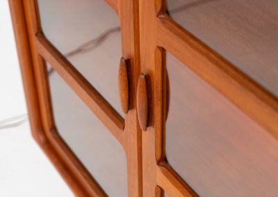 Stunning showcase by Svend Dyrlund (Denmark, 1960s). This exceptional piece features elegant doors with glass panels and beautifully crafted wooden handles, two adjustable shelves, and convenient backlights behind each shelf to highlight your displayed items. Made from rich teak with a natural woodgrain, it perfectly combines functionality with the timeless characteristic of Danish modern design. In splendid condition & labeled by maker.