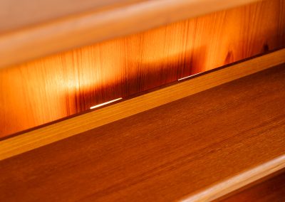 Stunning showcase by Svend Dyrlund (Denmark, 1960s). This exceptional piece features elegant doors with glass panels and beautifully crafted wooden handles, two adjustable shelves, and convenient backlights behind each shelf to highlight your displayed items. Made from rich teak with a natural woodgrain, it perfectly combines functionality with the timeless characteristic of Danish modern design. In splendid condition & labeled by maker.