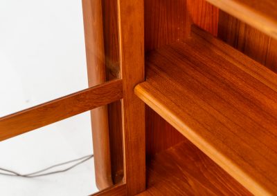 Stunning showcase by Svend Dyrlund (Denmark, 1960s). This exceptional piece features elegant doors with glass panels and beautifully crafted wooden handles, two adjustable shelves, and convenient backlights behind each shelf to highlight your displayed items. Made from rich teak with a natural woodgrain, it perfectly combines functionality with the timeless characteristic of Danish modern design. In splendid condition & labeled by maker.