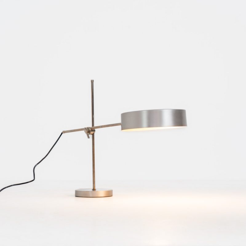 Stunning modernist angling table lamp. We don’t know who made this beauty for now, but it is probably produced in Italy around the 60s. The lamp is made out of a chrome stem and an aluminium base & shade. It is fully adjustable in height & angle with a high quality metal swivel joint. It’s in very good vintage condition with some mild age related surface scratches.
