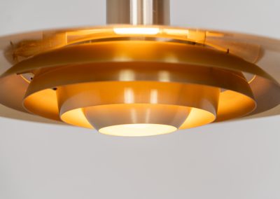 Early “P376” brass pendant light by Jørgen Kastholm & Preben Fabricius for Nordisk Solar (Denmark, 1960s). This magnificent lamp features a series of gently curved, layered brass anodized aluminum shades that create a stunning glow. Designed in the 1960s, it exemplifies Danish modernism with its clean lines and refined aesthetic, making it a timeless choice for both classic and contemporary interiors. The P376 is a true design icon! The lamp is in good vintage condition with a beautiful patina. It has some surface scratches and age related discolorations.