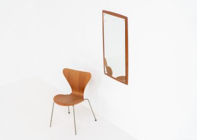 Mid-Century wall mirror by Ølholm Møbelfabrik (Denmark, 1960s). A very elegant wall mirror with a sculptural and detailed appearance, made out of solid teak. In good vintage condition. The glass shows some age related marks.