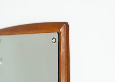 Mid-Century wall mirror by Ølholm Møbelfabrik (Denmark, 1960s). A very elegant wall mirror with a sculptural and detailed appearance, made out of solid teak. In good vintage condition. The glass shows some age related marks.