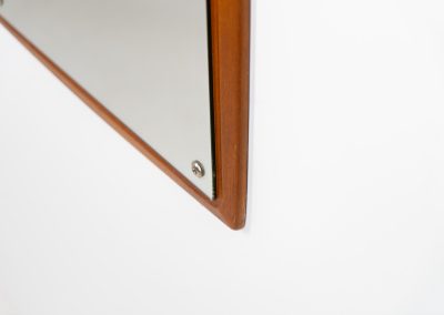 Mid-Century wall mirror by Ølholm Møbelfabrik (Denmark, 1960s). A very elegant wall mirror with a sculptural and detailed appearance, made out of solid teak. In good vintage condition. The glass shows some age related marks.