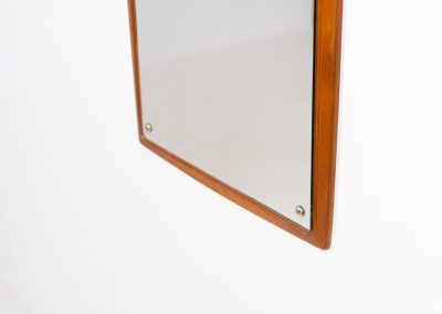 Mid-Century wall mirror by Ølholm Møbelfabrik (Denmark, 1960s). A very elegant wall mirror with a sculptural and detailed appearance, made out of solid teak. In good vintage condition. The glass shows some age related marks.