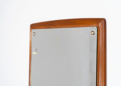 Mid-Century wall mirror by Ølholm Møbelfabrik (Denmark, 1960s). A very elegant wall mirror with a sculptural and detailed appearance, made out of solid teak. In good vintage condition. The glass shows some age related marks.