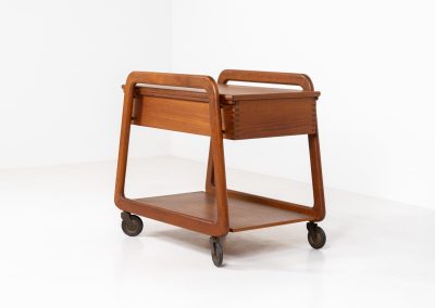 Teak serving trolley by Sika Møbler (Denmark, 1960s). An elegant and versatile piece crafted from warm teak. It features clean lines, dovetail joinery, and a functional two-tier design with a convenient drawer for storage. The trolley is mounted on smooth-rolling casters, making it both stylish and practical for serving or displaying items. The trolley remains in mint condition.