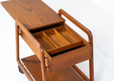 Teak serving trolley by Sika Møbler (Denmark, 1960s). An elegant and versatile piece crafted from warm teak. It features clean lines, dovetail joinery, and a functional two-tier design with a convenient drawer for storage. The trolley is mounted on smooth-rolling casters, making it both stylish and practical for serving or displaying items. The trolley remains in mint condition.