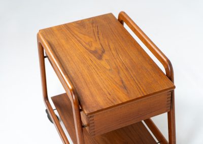 Teak serving trolley by Sika Møbler (Denmark, 1960s). An elegant and versatile piece crafted from warm teak. It features clean lines, dovetail joinery, and a functional two-tier design with a convenient drawer for storage. The trolley is mounted on smooth-rolling casters, making it both stylish and practical for serving or displaying items. The trolley remains in mint condition.