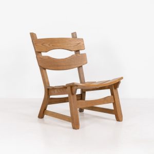 Brutalist lounge chair in solid oak by Dittmann & Co. for AWA Radboud (The Netherlands, 1960s). This robust fireplace chair, remeniscent of Pierre Chapo & Charlotte Perriand’s designs, is crafted out of solid oak and features a low comfortable seat and a vivid woodgrain. The chair is in a nice untouched vintage condition.