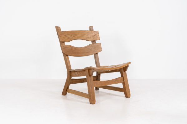 Brutalist lounge chair in solid oak by Dittmann & Co. for AWA Radboud (The Netherlands, 1960s). This robust fireplace chair, remeniscent of Pierre Chapo & Charlotte Perriand’s designs, is crafted out of solid oak and features a low comfortable seat and a vivid woodgrain. The chair is in a nice untouched vintage condition.