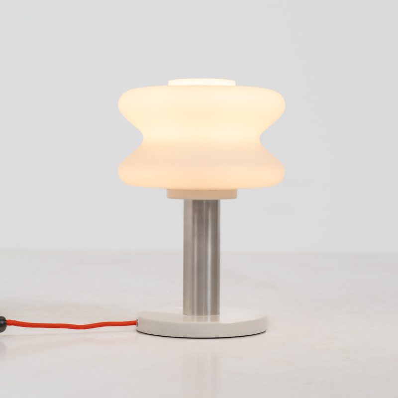 Modernist table lamp by AKA (Germany, 1960s). A beautiful table lamp with a heavy metal base, a brushed aluminium stem and and organically shaped, opal glass shade. The lamp is newly rewired and in very good condition!