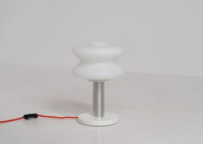 Modernist table lamp by AKA (Germany, 1960s). A beautiful table lamp with a heavy metal base, a brushed aluminium stem and and organically shaped, opal glass shade. The lamp is newly rewired and in very good condition!