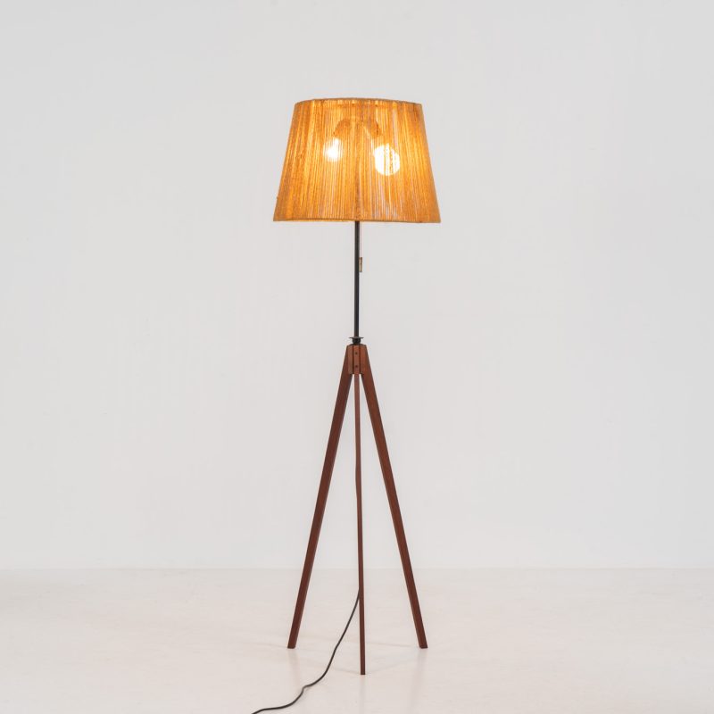 Midcentury Tripod floor (Germany, 1950s). This striking floor lamp consists of a solid teak tripod base, an adjustable metal arm and a beautiful sisal lampshade. It emits a warm, atmospheric glow when illuminated, enhancing any interior with its natural charm. The lamp remains in very good condition.