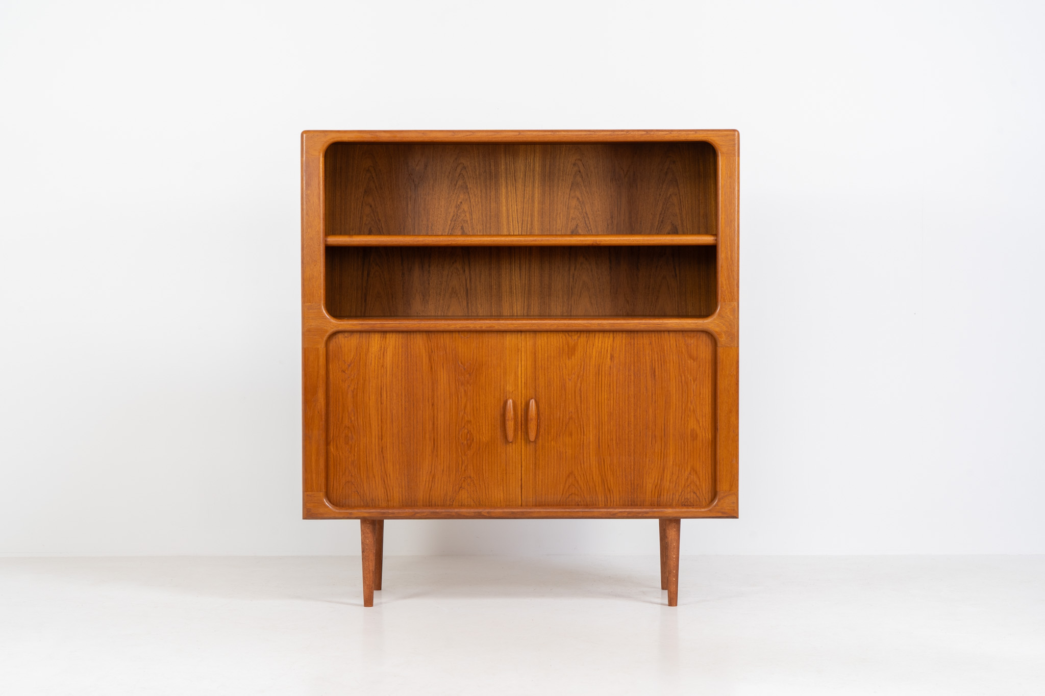 Beautiful bookcase in teak by Svend Dyrlund with tambour doors (Denmark, 1960s). This bookcase perfectly combines organic shapes and loads of details, like the tambour sliding doors, the beautiful handles or the bulky shelves, which are adjustable in height. It offers lots of storage space! In mint condition!