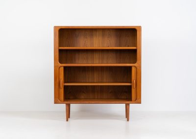 Beautiful bookcase in teak by Svend Dyrlund with tambour doors (Denmark, 1960s). This bookcase perfectly combines organic shapes and loads of details, like the tambour sliding doors, the beautiful handles or the bulky shelves, which are adjustable in height. It offers lots of storage space! In mint condition!